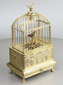 Vintage miniature gilt brass singing bird in cage, by Eschle